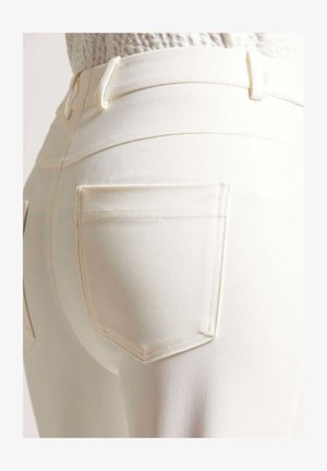 Witte denim jeans met een aansluitend ontwerp, voorzien van twee achterzakken, subtiele stikdetails en een gladde textuur.