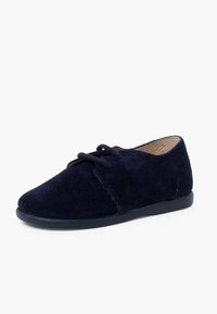 Pantof cu toc rotund din suede albastru marin, cu închidere cu șireturi și talpă plată din cauciuc; textură netedă, cu cusături și accente minime.