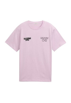 Camiseta de algodón rosa claro con mangas cortas. Presenta gráficos de texto en negro: "EL REMIX DEL MÁS ALLÁ" y "NO ES TAN SERIO, NUNCA TE QUEDES IGUAL."