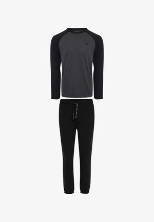 Schwarze Sweatpants mit elastischen Bündchen, kombiniert mit einem grauen Langarmshirt, das schwarze Raglanärmel und ein kleines Logo aufweist.