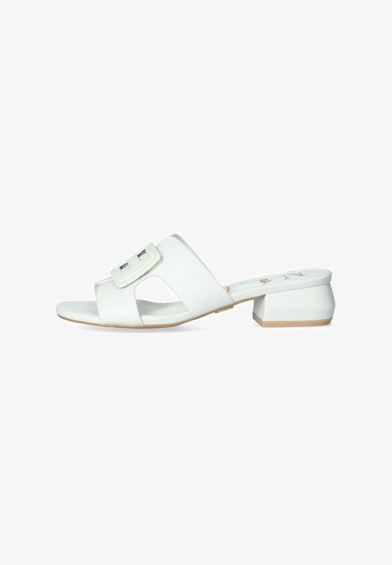 Sandali bianchi aperti con tacco basso a blocco. Realizzati in materiale sintetico liscio, con dettaglio di fibbia sovradimensionata e cinturini incrociati.