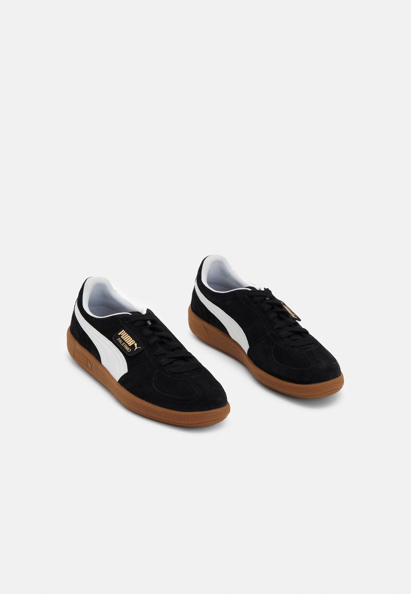 Pair of black suede Puma Palermo sneakers with white stripe and gum rubber soles, shown side by side on a white background.