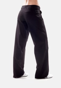 Black athletic pants with a wide-leg design, made of a smooth, stretchy material. Features an elastic waistband and side pockets.