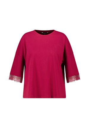 Haut rose ample à manches courtes avec col rond et détail en dentelle florale au niveau des extrémités des manches.