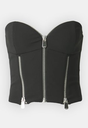 Svart croppet bustier med stroppeløst design, featuring to sølvglidelåser foran og en glatt, elastisk stofftekstur.