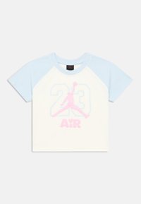Λευκό βαμβακερό μπλουζάκι με ανοιχτομπλε raglan μανίκια. Διαθέτει ροζ και μπλε γραφικά με τον αριθμό «23» και μια φιγούρα που πηδάει με το κείμενο «AiR».