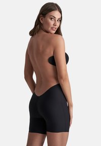 Zwarte strapless bodysuit met een laag uitgesneden achterkant, naadloze randen en een soepele textuur. Heeft een aansluitende pasvorm en een lengte tot halverwege de dij.