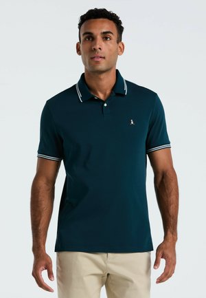 Donkerblauwe polo met een kraag met twee knopen, contrasterende witte afwerking op de kraag en mouwen, en een small logo op de borst.