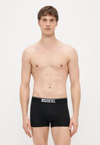 Μαύρα ανδρικά εσώρουχα boxer από βαμβάκι με εφαρμοστή σχεδίαση. Διαθέτουν ελαστική μέση με αντίθετο λογότυπο. Ομαλή υφή.