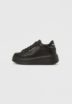 Black leather sneakers with a smooth finish, rounded toe, lace-up design, and thick platform sole featuring brand logo accents.