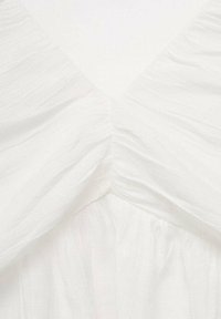 Weißes Kleid aus strukturiertem Stoff; mit einem V-Ausschnitt und gerafften Details, die sanfte Drapierungen erzeugen.