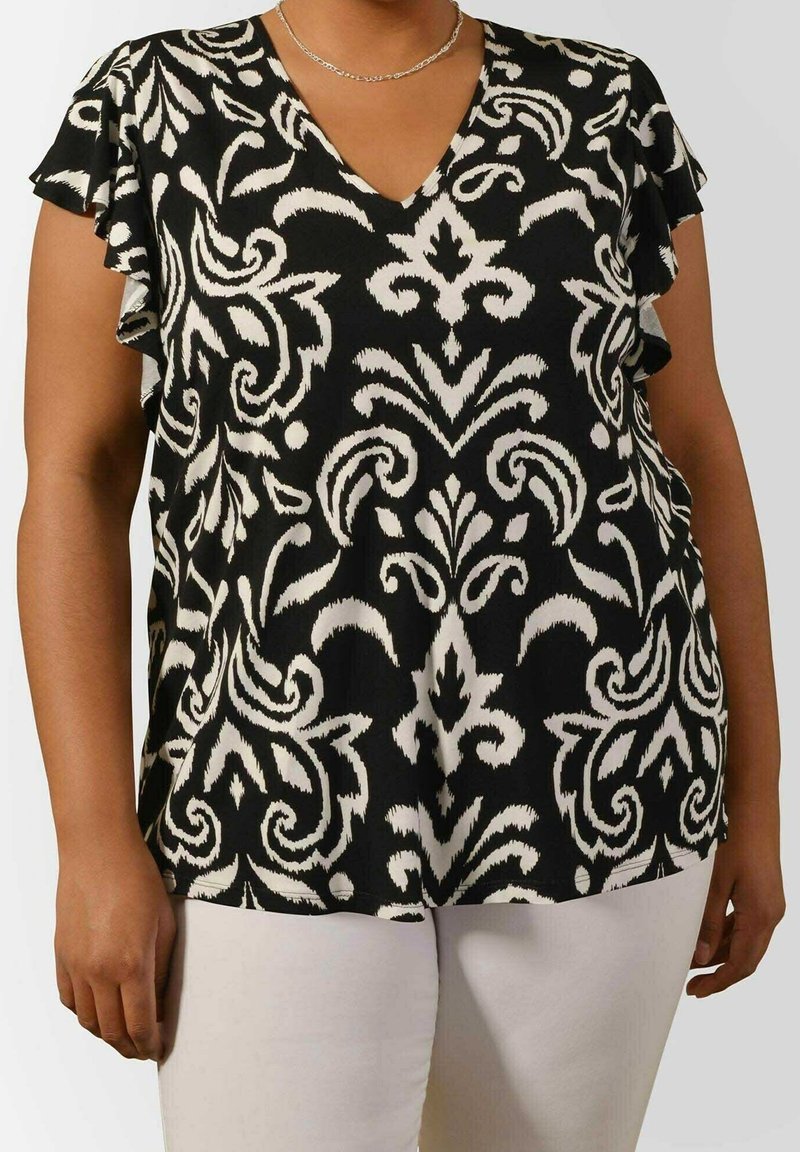 Svart och vit topp med V-ringning, med blommönster och volangade kortärmar. Tyget verkar lätt och har en slät textur.