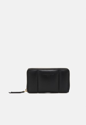 Portefeuille rectangulaire en cuir noir avec fermeture éclair tout autour, design de panneau cousu et petite languette sur fond blanc.