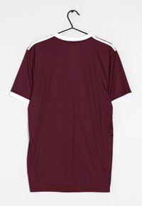 Camiseta atlética color marrón con mangas cortas. Acentos blancos en el cuello y los puños de las mangas. Material suave y ligero con una textura sutil.