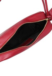 Borsa a tracolla rossa in pelle con una cerniera dorata, caratterizzata da un interno nero profondo e un design snello. La cerniera si apre per rivelare ampio spazio di archiviazione.