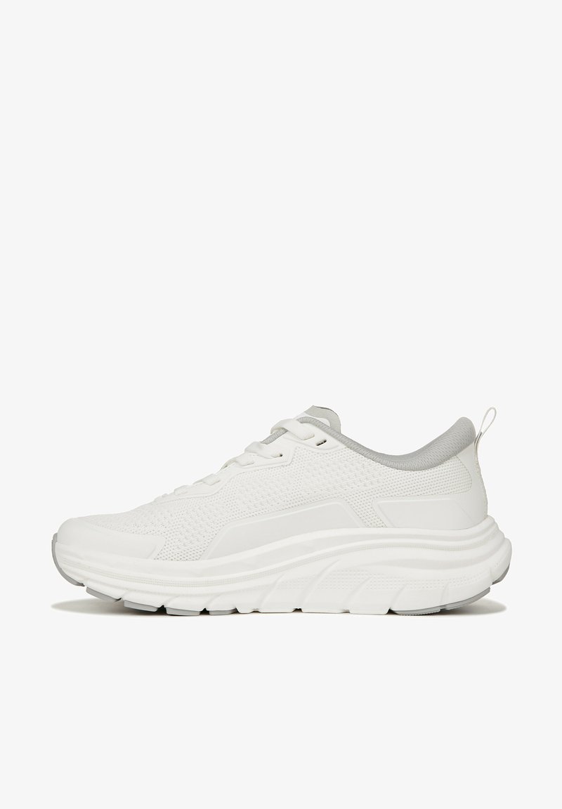 White athletic shoe with textured mesh upper, grey accents, and a thick cushioned sole for support. Features traditional lace-up design and pull tab.