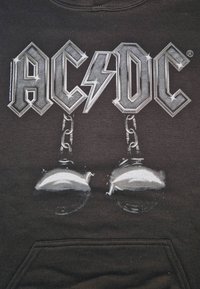 Zwarte hoodie met een "AC/DC" graphic in metallic zilver, versierd met kettingen en een belontwerp. Gemaakt van katoen en voorzien van een voorvak.