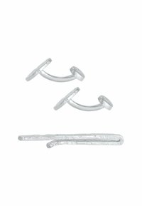 Accessori per capelli in metallo argentato, compresi due fermagli circolari con steli curvi e un fermaglio piatto con una finitura testurizzata.