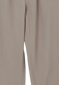 Pantalons beiges avec une texture lisse, présentant une coupe allongée, un design minimaliste et des coutures sur les côtés pour une apparence ajustée.
