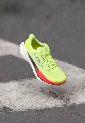 Limegrøn løbesko med mesh-overdel, polstret sål og logodetaljer. Har en gradient fra rød til lilla accent på sålen.