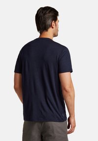 Navy blue short-sleeve t-shirt made of soft fabric, featuring a crew neckline and a small branded tag on the left side seam.