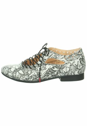 Chaussure noir et blanc à lacets avec un motif graphique, tige en simili cuir, bout pointu, talon plat et petites découpes sur les côtés.