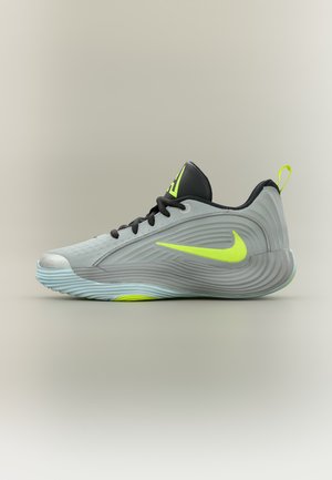 Светлосив Nike кец с черни връзки, неоново жълто лого и акценти и текстурирана подметка, показан в профил на неутрален фон.