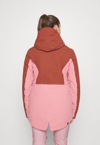 Rosa och brun färgblockerad jacka med huva, med en slät textur och f�örlängd bakhem. Designad för utomhusbruk.