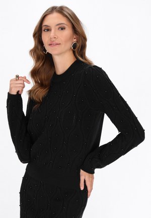 Pulover negru tricotat cu un model texturat și broderii. Mâneci lungi și gât rotund. Țesătură netedă cu un talie ajustată.