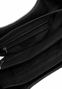 Must musta käsikott musta nahast sisemusega, millel on tekstuuriga pind, mitme lukuga tasku ja peamine sektsioon mustast kangast.