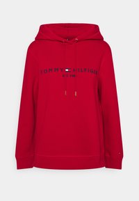 Czerwona bluza z kapturem wykonana z bawełny, z haftowanym granatowym logo "TOMMY HILFIGER" oraz złotymi sznurkami do regulacji. Prążkowane mankiety i dół.