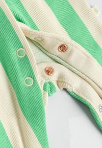 Ribbade baby bodysuit med växlande gröna och krämfärgade ränder, plasttryckknappar och metalliska accenter vid halsringningen.
