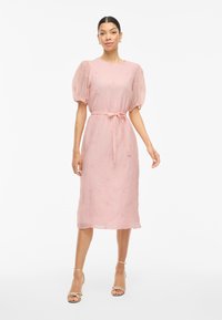 Rosa, medellång klänning i texturerad tyg, med puffärmar, midjebälte och blommönstrade broderidetaljer.