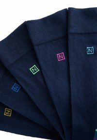 Calcetines azul marino con logos cuadrados de colores; incluye acentos en rosa, verde, azul y amarillo. Tejido texturizado con puños acanalados.