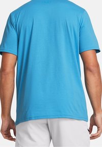 Ljusblå t-shirt med kort ärm, tillverkad av mjukt tyg. Den har en enkel design med rund hals och inga synliga mönster eller grafiker.