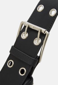 Cintura in pelle nera con accessori in argento, grandi occhielli in metallo e una fibbia rettangolare con marchio inciso. Finitura testurizzata su tutta la superficie.
