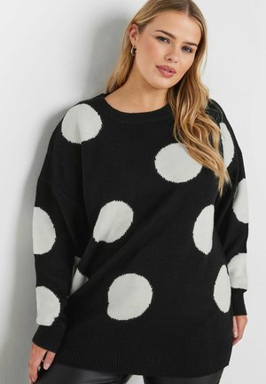 Pull en tricot noir avec de grands pois blancs ; coupe décontractée, encolure ronde, manches longues, et poignets et ourlet côtelés.