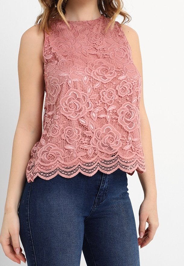Krajkový top bez rukávů v jemné růžové barvě, s květinovým vzorem, vroubkovaným lemem a hladkou texturou, kombinovaný s tmavě modrými džínami.