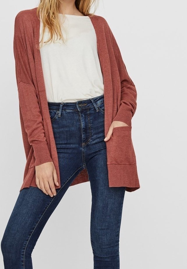 Cardigan i rustfarve lavet af blødt stof, med åben front, lange ærmer og ribstrikkede detaljer, kombineret med tætsiddende mørke jeans.