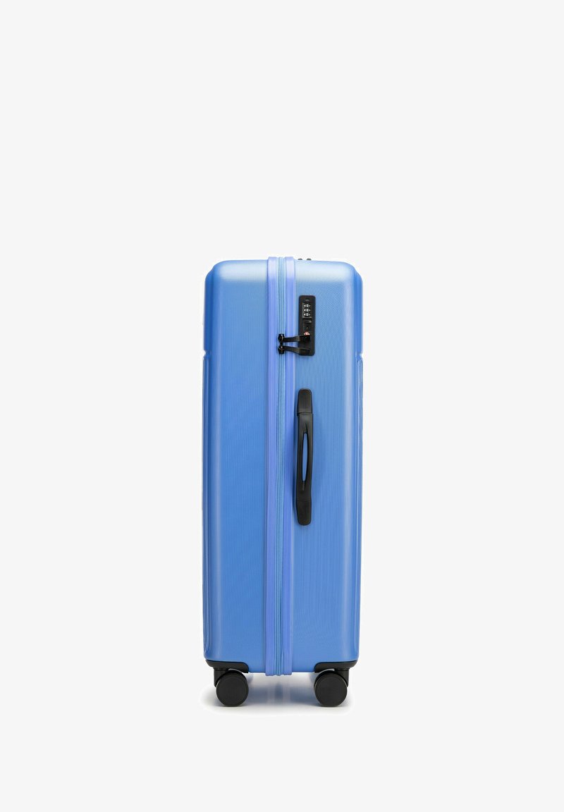Large blue hard-shell suitcase with a textured surface, dual zippers, black handle, and four black wheels for easy mobility.