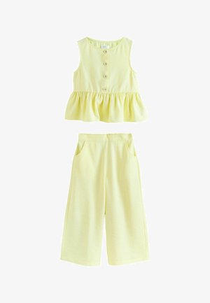 Top galben pal fără mâneci, cu nasturi în față și talie cu volane, combinat cu pantaloni largi asortați, cu buzunare laterale.