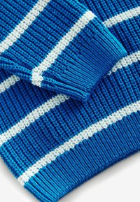 Maglione azzurro lavorato a maglia con strisce orizzontali bianche, tessuto testurizzato, polsini a costine e una finitura liscia, vista ravvicinata.