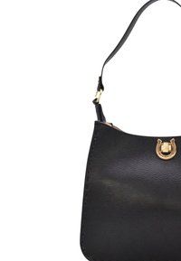 Czarna skórzana torebka z złotym zapięciem w kształcie podkowy oraz jedną regulowaną ramiączkiem na białym tle.