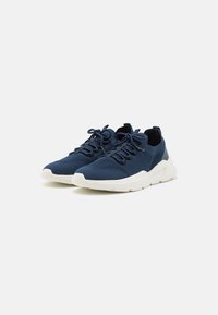 Marine gebreide sneakers met een afgeronde neus, vetersluiting en een witte rubberen zool. Heeft een gestoffeerde bovenkant en een gewatteerde kraag.