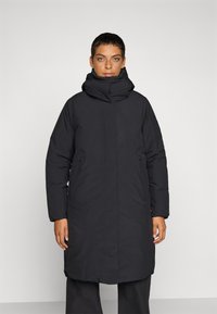 Zwarte gewatteerde jas met een hoge kraag en een rits aan de voorkant. Bevat zijzakken en heeft een relaxed fit, gemaakt van glad, geïsoleerd materiaal.