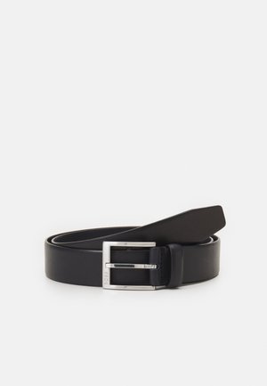 Ceinture en cuir noir avec une texture lisse, boucle en métal argenté et design rectangulaire. L'extrémité possède une pointe pour un maintien sécurisé.