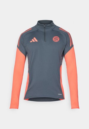 Harmaa urheilullinen pitkähihainen paita, jossa on neljännesvetoketju, korallinväriset yksityiskohdat olkapäillä ja hihoissa sekä Bayern Münchenin logo rinnassa. Aeroready-teknologia.