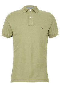 Polo shirt olive green à manches courtes avec deux boutons blancs et un petit logo rectangulaire rouge, blanc et marine sur la poitrine.