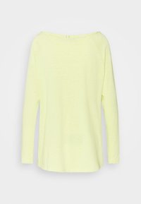 Långärmad topp med avskuren axel i starkt gult, med en mjuk textur och en avslappnad passform med krökt nederkant.