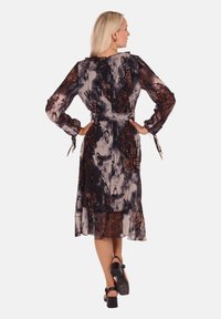 Chiffonkleid mit einer Mischung aus dunkelbraunen und grauen abstrakten Mustern, langen Ärmeln, tailliertem Bund und einem fließenden Schnitt in Midikalblänge.